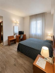 a hotel room with a bed and a desk at Hotel Italia in Ravenna