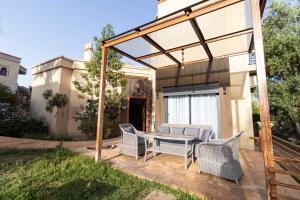 a patio with a table and chairs on it at Rose Garden Resort & Spa in Marrakesh