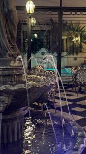 a fountain in the middle of a building with a statue at Le Flâneur Boutique Hotel in Pergamino
