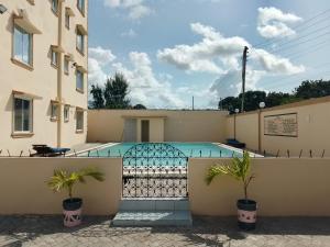 a swimming pool in front of a building at Summer Malindi Family House in Malindi