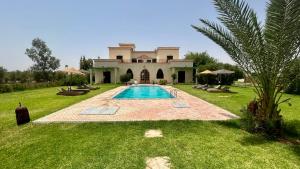 a large house with a swimming pool in the yard at Villa Riad Ambre in Douar bel Rhanodour