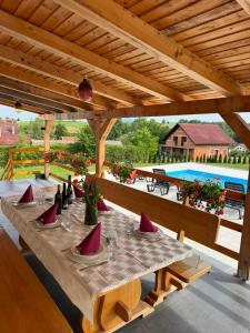a wooden table with red pillows on a patio at Plitvice House Lina in Rakovica