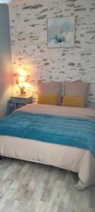 a bedroom with a bed and a stone wall at Entre vigne et Loire in La Coindassière