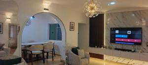 ein Wohnzimmer mit Fernseher, Tisch und Stühlen in der Unterkunft Harrington Duplex in Meran