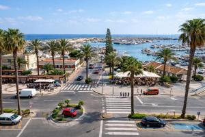 a city street with palm trees and a harbor at Palmeras Puerto Torrevieja in Torrevieja