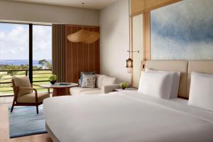 a bedroom with a white bed and a table and chairs at The Ritz-Carlton Okinawa in Nago +90 photos