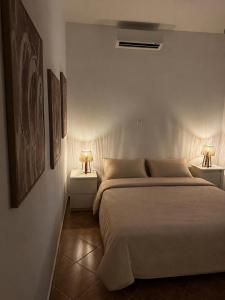 a bedroom with a bed and two lamps on tables at Villa Panόrama in Riglia