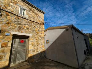 a stone building with a door with a red star on it at 好馨情民宿 in Nangan