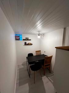 un comedor con mesa y sillas negras en The Hideout, en Estocolmo