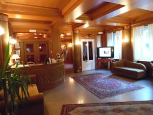 a large living room with a couch and a television at Hotel Auronzo in Auronzo di Cadore