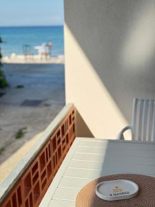 a plate on a table on a balcony with the ocean at Xanthos Beachfront Suites in Potamiá