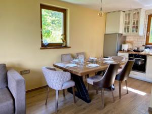 a dining room with a wooden table and chairs at Vila Vlasinski mir in Surdulica