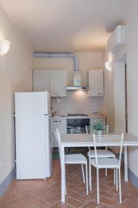 a kitchen with a white refrigerator and a table and chairs at Terrediliguria - Lerici in Lerici