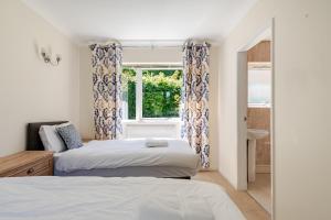 a bedroom with two beds and a window at The Limes Bungalow in Market Rasen +54 photos