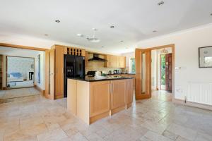 a kitchen with wooden cabinets and black appliances at The Limes Bungalow in Market Rasen
