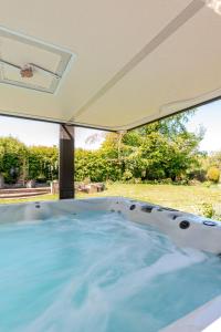 a jacuzzi tub in a backyard with a window at The Limes Bungalow in Market Rasen