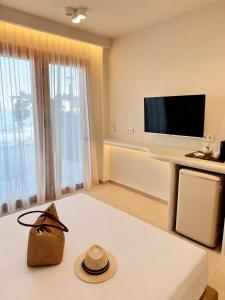 a living room with a hat and a television at Xanthos Beachfront Suites in Potamiá
