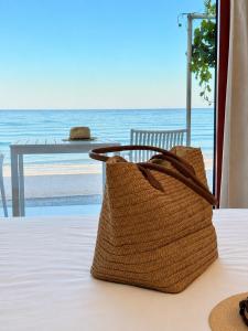 a rattan bag sitting on a table with a view of the ocean at Xanthos Beachfront Suites in Potamiá