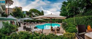 a pool with tables and chairs and an umbrella at Cardinal Hotel St. Peter in Rome