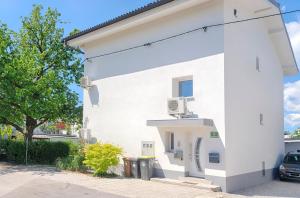 a white building with a car parked next to it at Studio Southwest 1 with AirCon & FREE Parking in Ljubljana