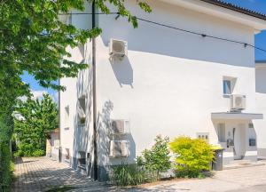 a white building with two air conditioners on it at Studio Southwest 1 with AirCon & FREE Parking in Ljubljana