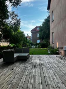 una terraza de madera con un sofá y una mesa y un edificio en The Hideout, en Estocolmo