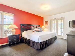 a bedroom with a bed and a red wall at 3BR Home Trailside Pool & Jacuzzi, Minutes from Inverness, Ocala & Crystal River in Inverness +18 photos