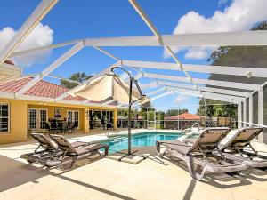 a patio with chairs and a swimming pool at 3BR Home Trailside Pool & Jacuzzi, Minutes from Inverness, Ocala & Crystal River in Inverness