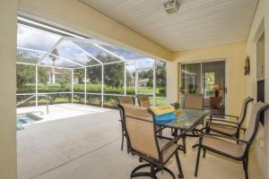 a screened in porch with a table and chairs at Villa Mourik in Inverness