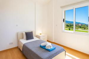 a bedroom with a bed and a window at Villa Myla in Kato Yialia