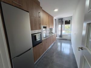 a kitchen with wooden cabinets and a stove top oven at Apartamentos Illa Pancha in Ribadeo