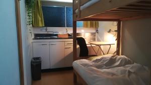a bedroom with a bunk bed and a kitchen with a table at Guesthouse Oasis in Osaka +27 photos