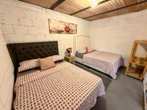 a bedroom with two beds and a brick wall at Villa campestre Las Palmas in Calima +3 photos