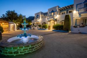 a fountain in a courtyard in front of a house at Elpiniki in Alinda
