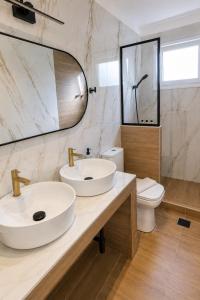 a bathroom with two sinks and a toilet at Goldtown House in Chrysoupolis +19 photos