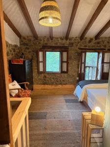 a bedroom with a bed and a chandelier at La aldea de lug in Rozagás