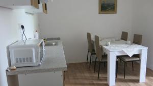 a kitchen with a white table with chairs and a microwave at Zámecký areál Dub in Dub