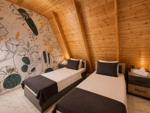 two beds in a room with wooden walls at Area36 Family Chalet in Gabala +23 photos