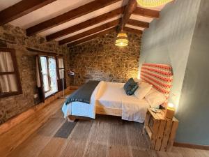 a bedroom with a bed and a brick wall at La aldea de lug in Rozagás