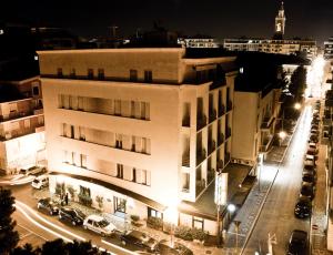 un edificio con auto parcheggiate fuori di notte di Hotel Ambra Palace a Pescara