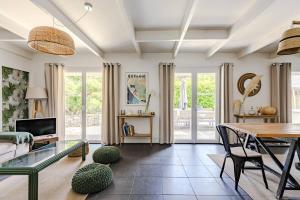a living room with a table and a dining room at maison familiale à 2 pas du lac,avec spa, à la Gde Escoure-grives in Lacanau