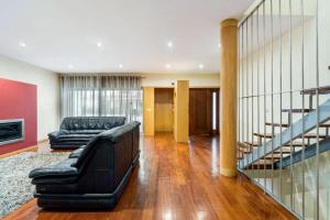 a living room with a couch and a staircase at Mansion with Swimming Pool, Pool Table & GrillArea in Braga