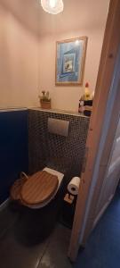 a bathroom with a toilet with a wooden seat at Le cocon in Carpentras