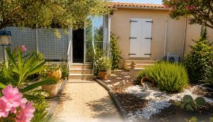 a garden with plants and a house with a door at Le cocon in Carpentras