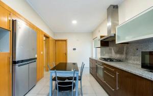 a kitchen with a table and some chairs in it at Mansion with Swimming Pool, Pool Table & GrillArea in Braga