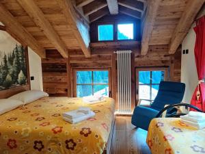 a bedroom with two beds in a log cabin at NUBERLAND nuovo alloggio appena ristrutturato e inaugurato in Gaby