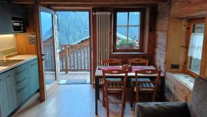 a kitchen with a table and chairs and a balcony at NUBERLAND nuovo alloggio appena ristrutturato e inaugurato in Gaby