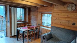 a dining room with a table and chairs in a cabin at NUBERLAND nuovo alloggio appena ristrutturato e inaugurato in Gaby +7 photos