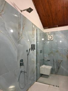 a bathroom with a shower and a toilet at Vanvaas the forest note in Godarpura