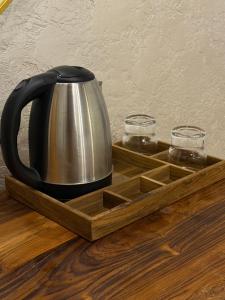 a tea kettle and two glasses in a wooden tray at Vanvaas the forest note in Godarpura